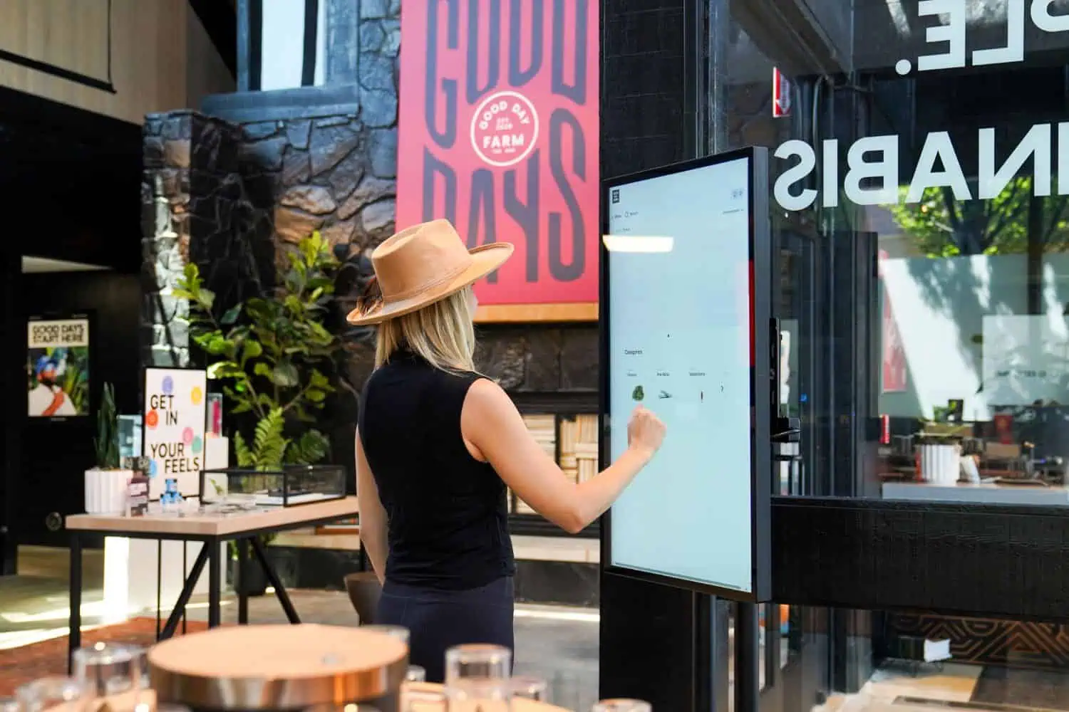 woman standing in front of a dispensary menu board